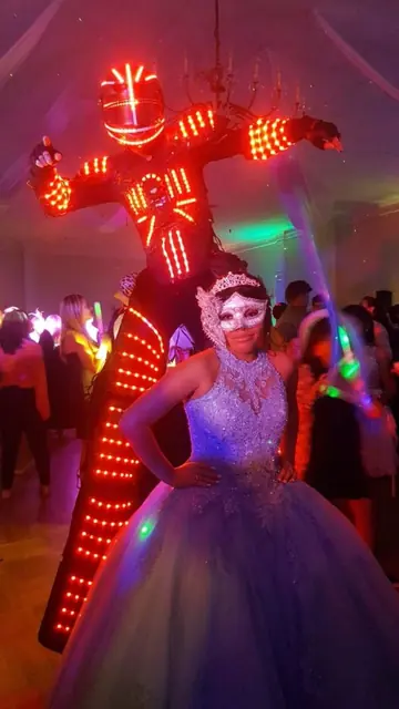 Robot LED junto a una quinceañera en plena hora loca